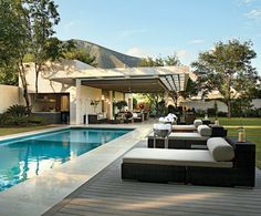 an outdoor living area next to a swimming pool