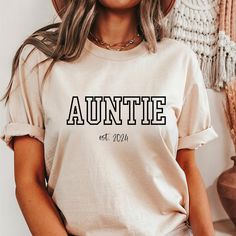 This Auntie Shirt is the perfect gift! ❤️ This Auntie T-shirt is made with the highest quality materials and is comfortable and cute! This Personalized Shirt would make a great gift for a new aunt or for an aunt that you want to show some love to!  How to Order: Select shirt size, select shirt color, and type year personalization request in box.  Font is black on all shirts, except white font on the black shirts. Sizing: Unisex fit. Please see size chart in the listing. You might also measure your favorite tee and compare to the size chart to find the best fit for you. Sleeves may be rolled up in some photos- they will not come rolled up upon arrival. Material: -BellaCanvas 3001 Unisex Tee -100% Airlume combed and ring-spun cotton, a lightweight fabric (4.2 oz/yd² (142 g/m  -Unisex fit -Te Auntie Tee Shirts, Short Sleeve Shirt With Name Print For Gift, Letter Print Crew Neck Tops For Gifts, Relaxed Fit Tops With Custom Text For Gifts, Relaxed Fit Tops With Custom Text As Gift, Short Sleeve Shirt With Letter Print For Gift, Short Sleeve Shirt With Letter Print As Gift, Crew Neck Shirt With Letter Print As A Gift, Custom Print Relaxed Fit Shirt As Gift