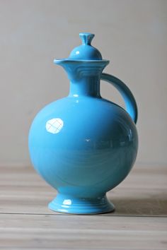 a blue vase sitting on top of a wooden table