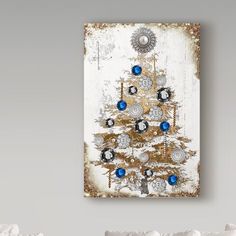 a white christmas tree with blue ornaments on it