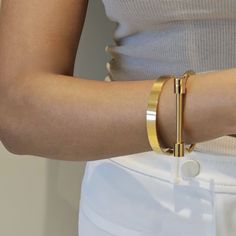 Our Screw Cuff Bangle in gold is the perfect stacking bangle. It features a high polished glossy design for a minimalist look. You can wear this minimalist bangle alone or stacked. Add a touch of sleek elegance to your outfit with our Screw Cuff Bangle. Its minimalist design is perfect for stacking with your other favourite accessories, or wearing alone for a sophisticated and effortless look. With its high polished finish, this bangle is sure to catch the eye and complete your style. This item Minimalist Gold-tone Bangle Bracelets, Minimalist Gold-tone Bangle Bracelet, Minimalist Gold Metal Cuff Bracelet, Modern Gold-tone Gold Plated Cuff Bracelet, Chic Gold Cuff Jewelry, Chic Gold Cuff Bracelet Tarnish Resistant, Minimalist Metal Cuff Bracelet, Tarnish Resistant, Minimalist Metal Cuff Bracelets, Modern Gold Cuff Jewelry