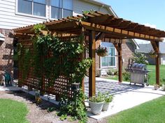 a pergolated covered patio in front of a house