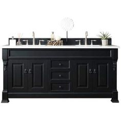 the double sink vanity is black and has two mirrors above it, along with an air plant