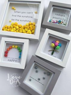 three framed pictures with different sayings on them and some paper flowers in the middle