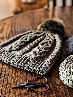 two knitted hats sitting on top of a wooden table