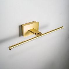 a gold toilet paper holder on a white wall