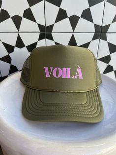 Exclusively from Passport Habits, our newest version of trucker hats have your favorite greetings from your favorite destinations! Voila means "There it is" in French. What a wonderful way to express your happiness in whatever comes your way! Available in yellow, red, navy blue, black, turquoise and army green Hats have a mesh backing and are adjustable. Green Snapback Trucker Hat For Vacation, Green Trucker Hat With Letter Print, Green Trucker Hat With Letter Print And Curved Bill, Green Trucker Hat With Curved Brim For Travel, Green Letter Print Trucker Hat For Beach, Green Letter Print Trucker Hat For The Beach, Green Trucker Hat With Letter Print For The Beach, Casual Green Trucker Hat For Gift, Casual Green Trucker Hat Gift