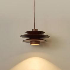 a light fixture hanging from the ceiling in a room with white walls and flooring