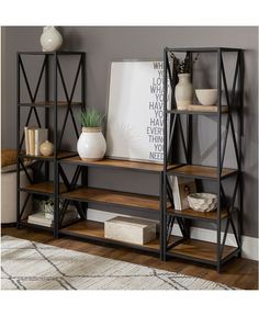 a book shelf with three shelves and two vases on the top, in front of a gray wall