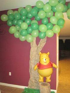 a winnie the pooh balloon tree with green balloons