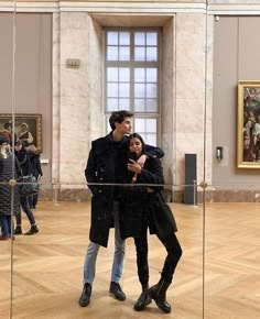 a man and woman standing next to each other in a museum