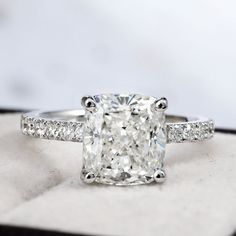 a cushion cut diamond ring with pave set shoulders