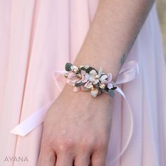 a close up of a person wearing a pink dress with flowers on it's wrist