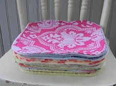 stack of pink and white fabric sitting on top of a wooden chair