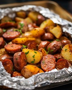 cooked sausage and potatoes in foil with parsley on top