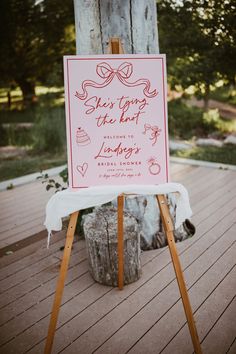 a sign that says she's trying the knot to be engaged on top of a wooden easel