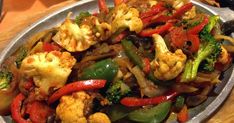 a plate full of mixed vegetables on a wooden table