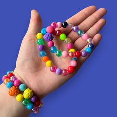 Brighten up any outfit with these handmade elastic rainbow bead bracelets! Each one is unique and adds a pop of color to your style. No need to worry about matching - mix and match colors for a fun and vibrant look. (Colors may vary slightly due to their handmade nature.) Trendy Rainbow Beaded Bracelets, Trendy Multicolor Stretch Bracelet For Party, Fun Multicolor Stretch Bracelet For Party, Multicolor Fun Stretch Bracelet For Party, Cute Multicolor Stretch Bracelet For Party, Playful Multicolor Stretch Bracelet For Friendship, Colorful Stretch Bracelet With Large Round Beads, Colorful Beaded Cute Stretch Bracelet, Trendy Multicolor Stretch Bracelet With Round Beads