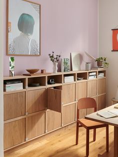 a room with wooden furniture and pink walls