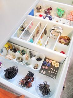 a drawer filled with lots of jewelry on top of a table