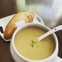 a bowl of soup with bread on the side