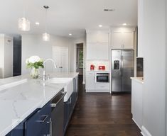 a large kitchen with white cabinets and marble counter tops, along with stainless steel appliances