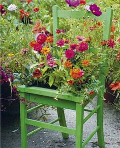 a green chair with flowers growing out of it