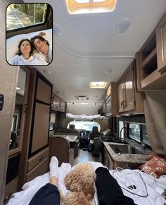 the interior of a camper with two people and a dog in it's bed