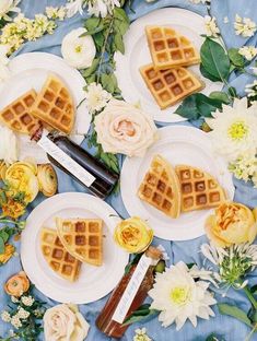 some waffles are sitting on plates with flowers around them