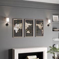 three framed maps hang on the wall above a fireplace