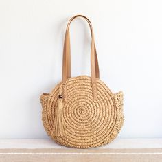 In Stock Fast Shipping From Los Angeles Carry your essentials in sweet, summery style with this Straw Circle Tote Handbag from Elena Handbags. This chic circular bag makes a great option for your warm weather errands like the farmer's market or thrifting, boasting an open-top design that provides quick and easy access to items inside. Double faux leather shoulder straps with whipstitch detailing add more texture to the look, while also providing comfortable carry over your shoulder as you go abo Summer Travel Crochet Bag With Round Handle, Spring Travel Beach Bag With Round Handle, Summer Fringe Bag For Everyday Use, Spring Travel Shoulder Bag With Round Handle, Casual Crochet Fringe Bag For Travel, Everyday Tassel Shoulder Straw Bag, Summer Crochet Travel Bag With Fringe, Casual Travel Straw Bag With Tassels, Casual Straw Bag With Tassels For Travel