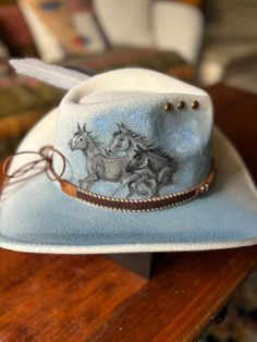 "Reigns of Freedom". A hand painted beauty for horse lovers! A cowboy style hat featuring a stamped of three horses, a detailed leather band with gold accents and a turkey feather. Adjustable to fit,  stain and water resistant. Decorated Horse, Cowboy Hat Design, Hat Burning, Three Horses, Custom Cowboy Hats, Cowgirl Stuff, Western Bedroom Decor, Western Bedroom, Felt Hats