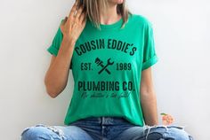 Cousin Eddie Plumbing Co Bella Canvas Shirt Perfect for any Christmas Vacation fan! No shitter's too full! This classic unisex jersey short sleeve tee fits like a well-loved favorite. Soft cotton and quality print make users fall in love with it over and over again. These t-shirts have-ribbed knit collars to bolster shaping. The shoulders have taping for better fit over time. Dual side seams hold the garment's shape for longer. .: 100% Airlume combed and ringspun cotton (fiber content may vary f Christmas With The Kranks Movie, Christmas With The Kranks, Griswold Family, Cousin Eddie, Funny Matching, National Lampoons Christmas Vacation, National Lampoons, Movie Tees, Tree Service