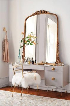 a dressing table with a mirror and stool