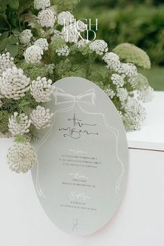 the wedding stationery is surrounded by flowers and greenery