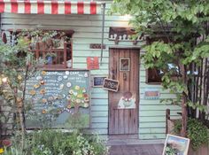 a small green building with a sign on the door