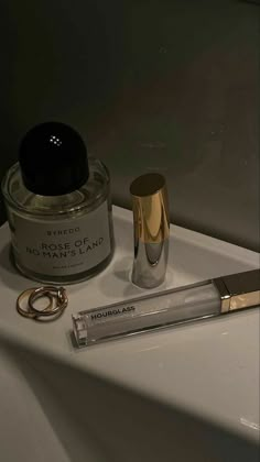 a close up of a bottle of perfume on a sink with a keychain