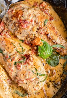 a pan filled with meat covered in sauce and vegetables