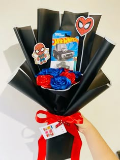 a person holding a bouquet of flowers in front of a white wall with spiderman stickers on it