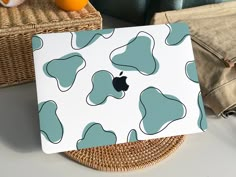 an apple computer sitting on top of a table next to oranges and a wicker basket