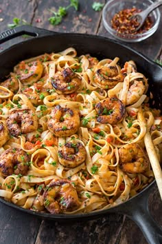 a skillet filled with pasta and shrimp