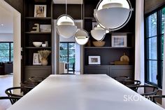 a large white table sitting in the middle of a room with lots of shelves and chairs