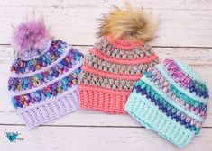 three crocheted hats with pom - poms on them sitting next to each other