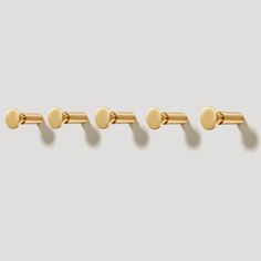 three pairs of gold - plated cufflinks on a gray background, each with four different sized dots