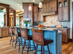 a kitchen with wooden floors and lots of stools in front of the bar area