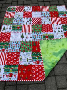 a red and green christmas quilt on the ground