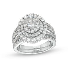 a white gold ring set with round diamonds on the shoulders and an oval halo setting in the center