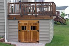 a garage with a wooden door and balcony above it