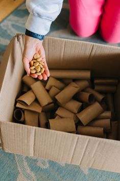 a person holding nuts in a cardboard box