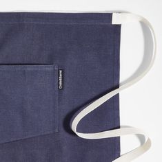 a blue bag with a white strap hanging from it's side and the pocket open